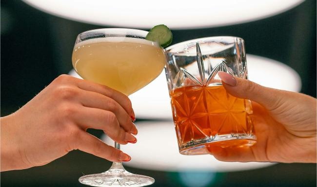 hands holding glasses with cocktails
